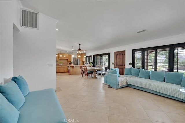 living room featuring ceiling fan, light tile patterned floors, and ornamental molding