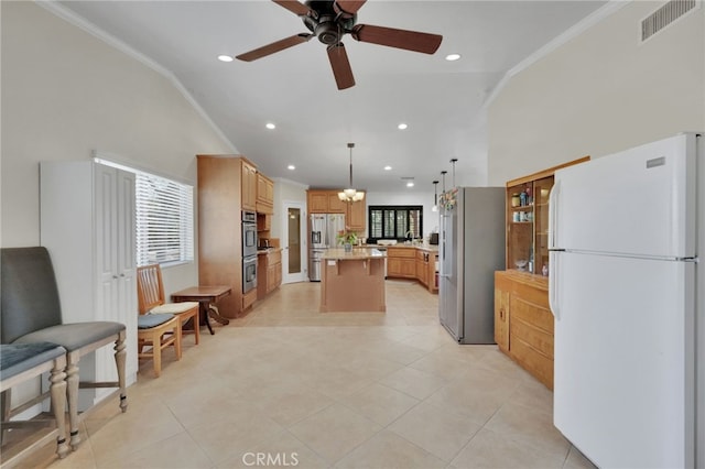 kitchen featuring lofted ceiling, a center island, decorative light fixtures, and appliances with stainless steel finishes