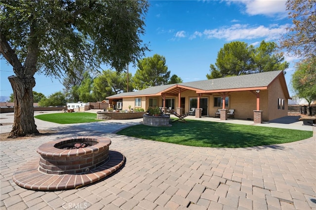 back of house featuring a yard and a fire pit