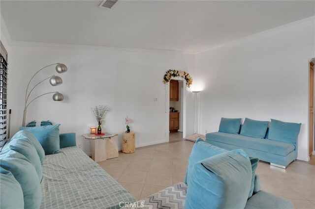 living room featuring light tile patterned floors and crown molding