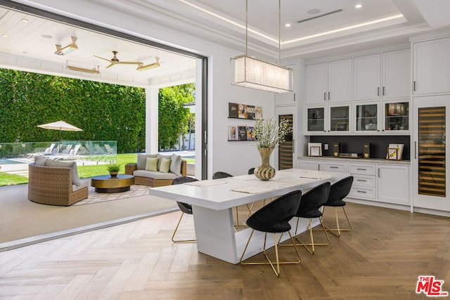 interior space with light parquet flooring, a raised ceiling, ceiling fan, and beverage cooler