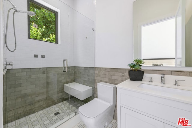 bathroom featuring an enclosed shower, vanity, tile walls, tile patterned flooring, and toilet