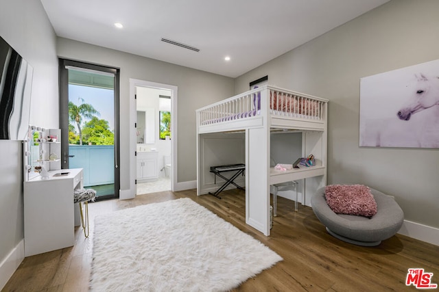 bedroom with ensuite bathroom and wood-type flooring