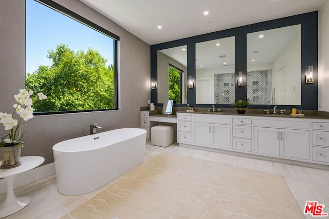 bathroom featuring tile patterned flooring, vanity, and shower with separate bathtub