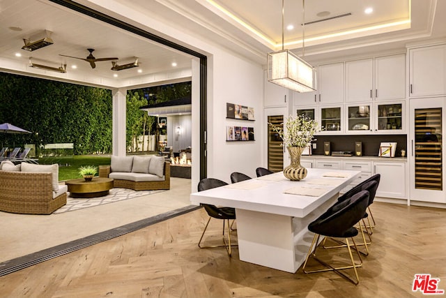 interior space with wine cooler, a tray ceiling, light parquet floors, and ceiling fan