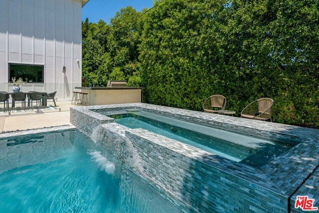 view of swimming pool with a patio area, an in ground hot tub, and an outdoor bar