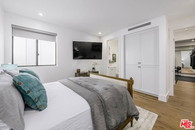 bedroom featuring connected bathroom and hardwood / wood-style floors