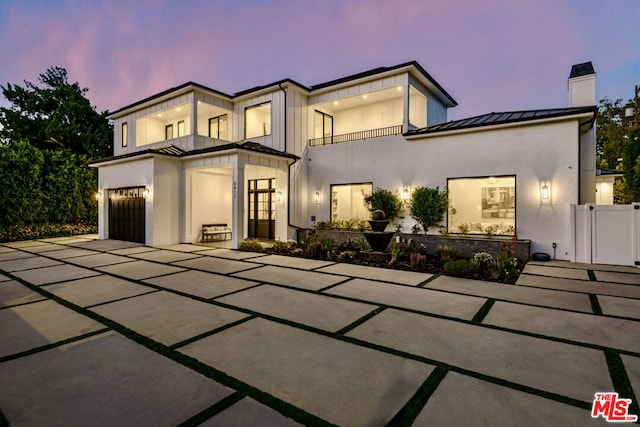 view of front of home with a garage and a balcony