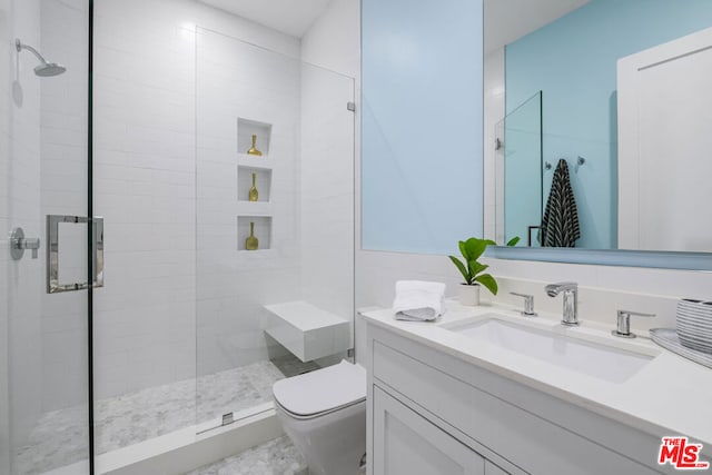 bathroom featuring a shower with door, vanity, and toilet