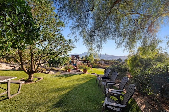 view of yard with a mountain view and a playground