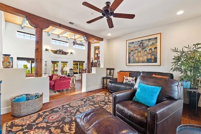 living room featuring dark wood-type flooring, ceiling fan, beam ceiling, french doors, and ornate columns