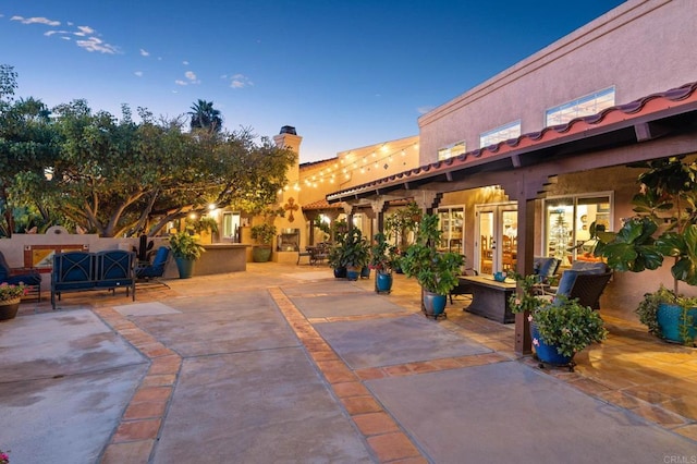 patio terrace at dusk featuring an outdoor living space