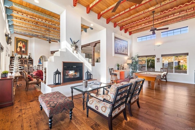 living room featuring billiards, wood ceiling, hardwood / wood-style flooring, beamed ceiling, and a high ceiling