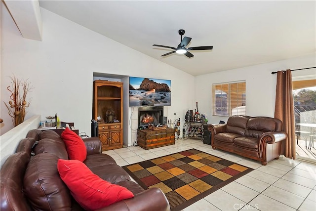 living room featuring ceiling fan, light tile patterned floors, and vaulted ceiling