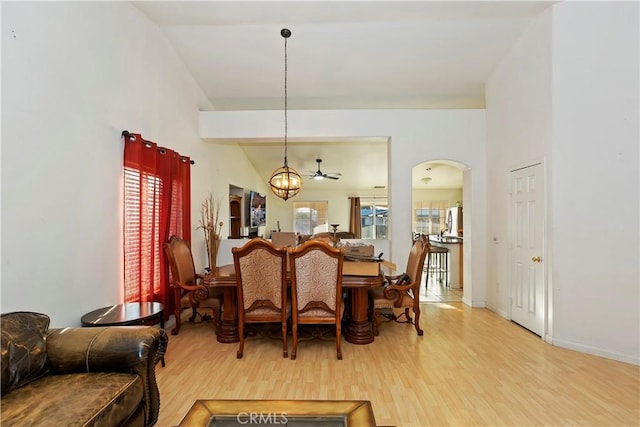 dining area with hardwood / wood-style flooring and ceiling fan with notable chandelier