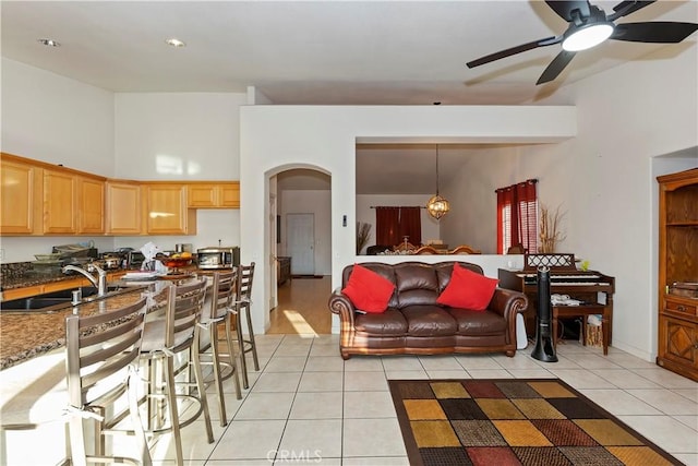 living room with ceiling fan, sink, and light tile patterned floors