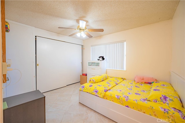 bedroom featuring a textured ceiling, ceiling fan, and a closet