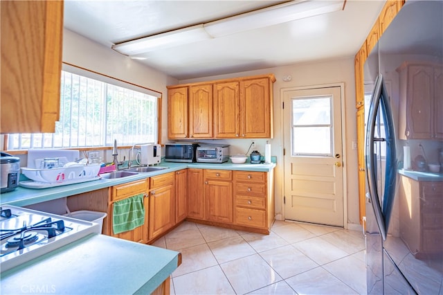 kitchen with a wealth of natural light, light tile patterned floors, and sink