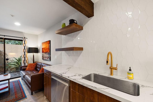 kitchen with light stone countertops, dishwasher, sink, tasteful backsplash, and light tile patterned floors