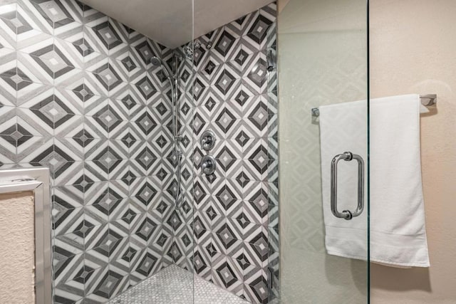 bathroom with a shower with door and tile walls