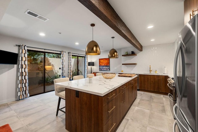 kitchen featuring pendant lighting, stainless steel fridge, beam ceiling, a kitchen island, and a kitchen bar