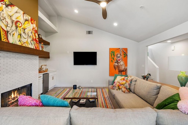 living room featuring a fireplace, ceiling fan, lofted ceiling, and sink