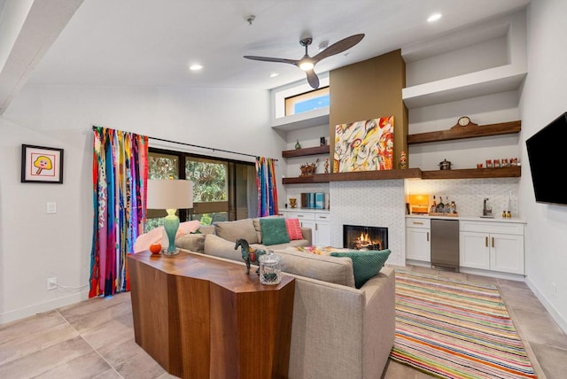 living room with ceiling fan, a healthy amount of sunlight, sink, and a tile fireplace