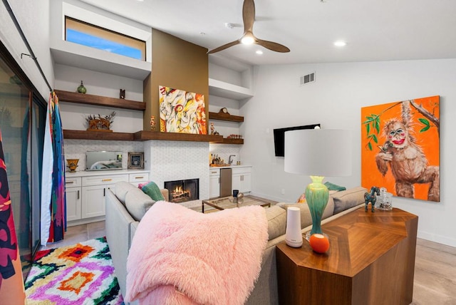 living room with light hardwood / wood-style flooring, ceiling fan, and lofted ceiling