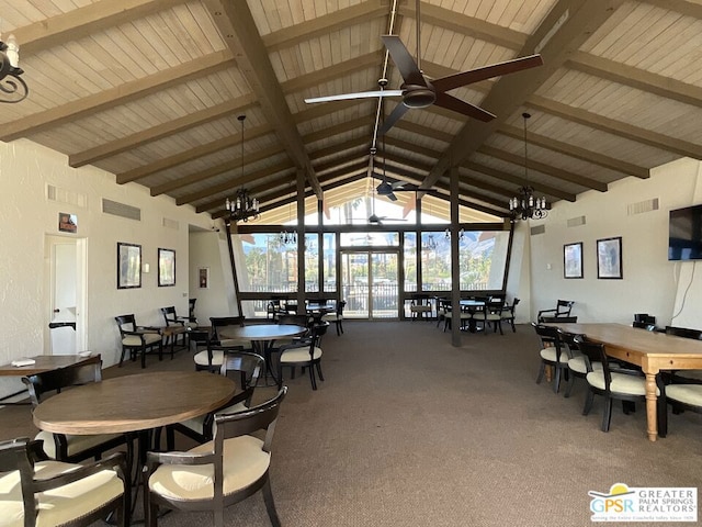 dining room with carpet flooring, beamed ceiling, and ceiling fan with notable chandelier