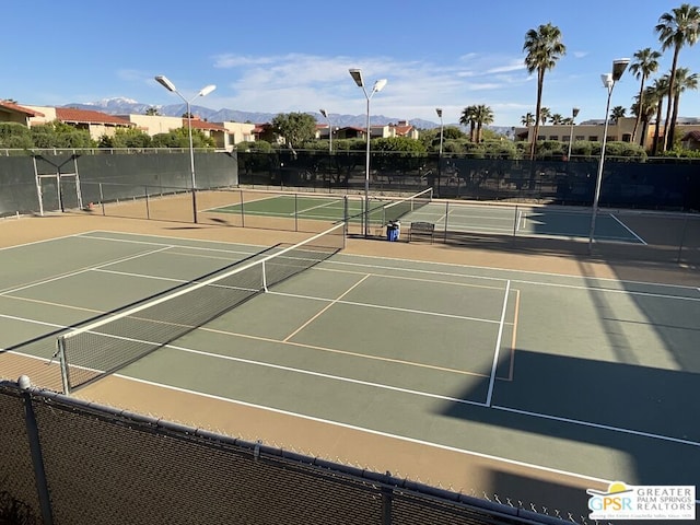 view of tennis court featuring a mountain view and basketball hoop