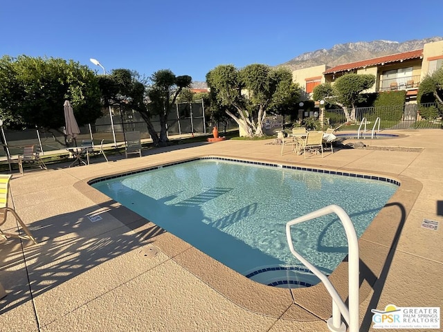 view of swimming pool with a mountain view and a patio