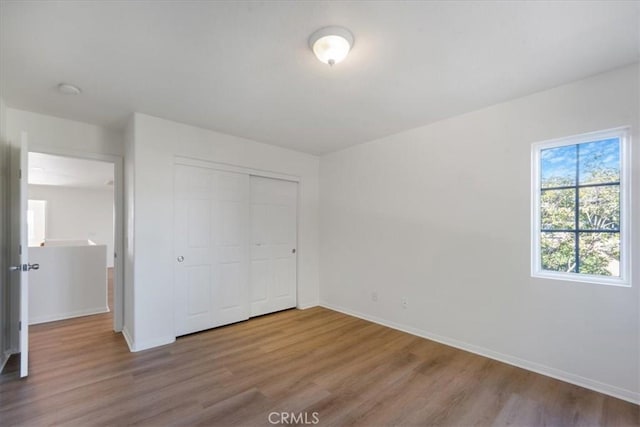 unfurnished bedroom with light hardwood / wood-style floors and a closet