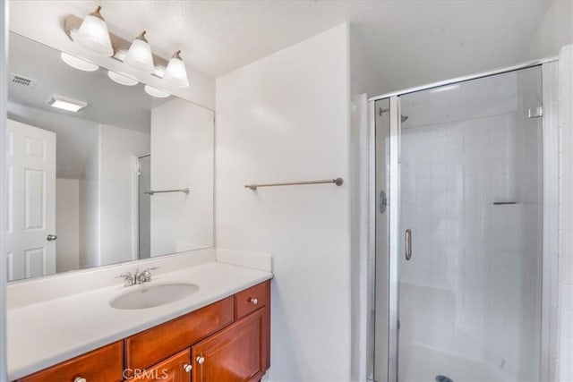 bathroom with vanity and a shower with shower door