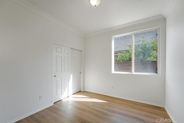 unfurnished room with light wood-type flooring and crown molding