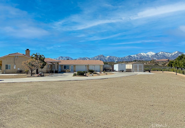 ranch-style house with a storage unit and a mountain view