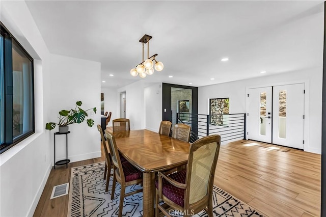 dining room with hardwood / wood-style flooring and a chandelier