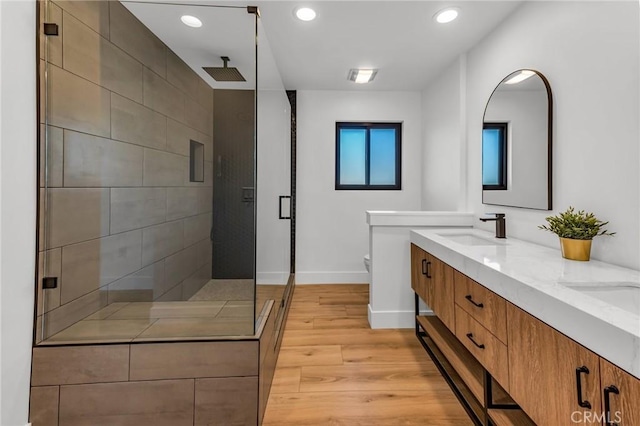 bathroom with hardwood / wood-style flooring, vanity, walk in shower, and toilet