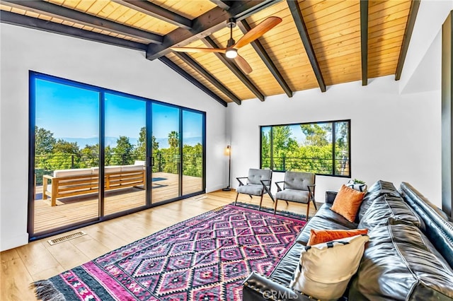 living room with vaulted ceiling with beams, wood ceiling, ceiling fan, and light wood-type flooring