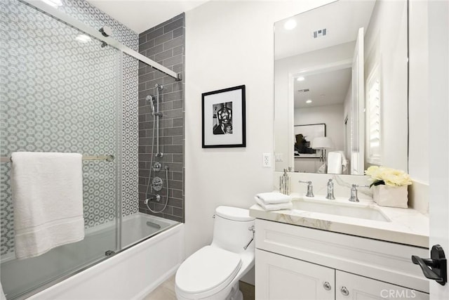 full bathroom featuring vanity, toilet, and shower / bath combination with glass door