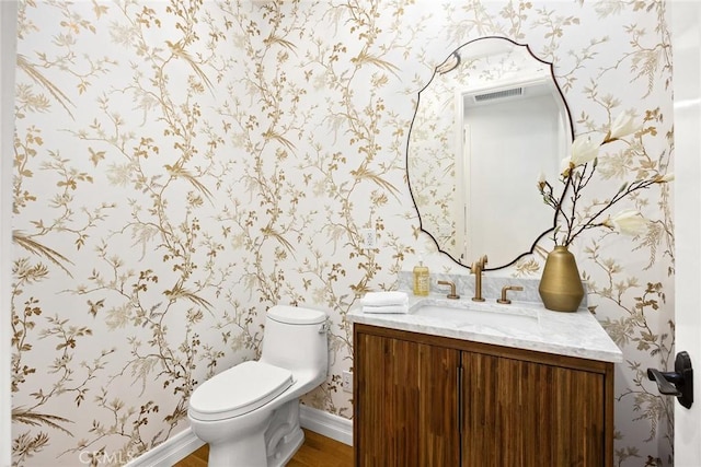 bathroom with hardwood / wood-style floors, vanity, and toilet