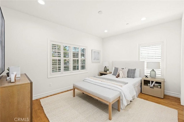 bedroom with hardwood / wood-style flooring and multiple windows