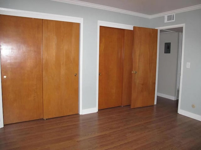 unfurnished bedroom with ornamental molding and dark wood-type flooring