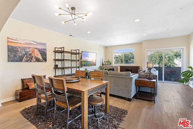 dining space with a notable chandelier and light hardwood / wood-style flooring