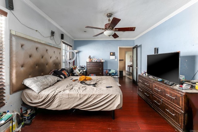 bedroom featuring dark wood-type flooring, ceiling fan, and ornamental molding