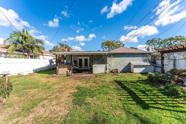 back of property featuring a lawn and french doors