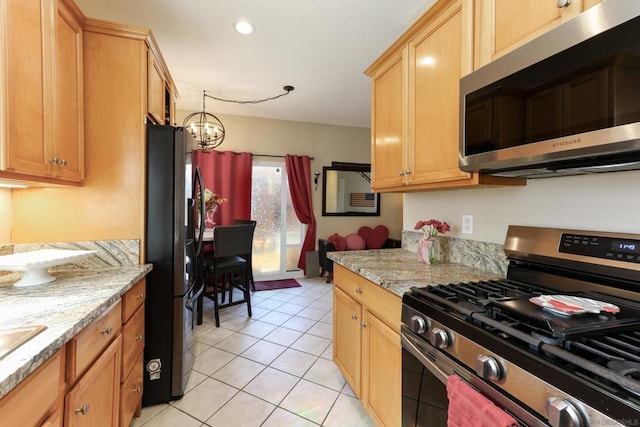 kitchen featuring a chandelier, stainless steel appliances, light stone countertops, and light tile patterned flooring