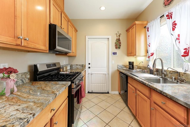 kitchen with light stone counters, sink, light tile patterned floors, and appliances with stainless steel finishes