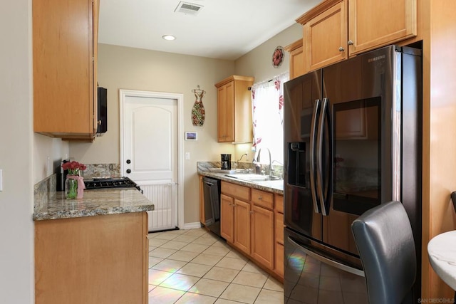 kitchen featuring light stone counters, sink, light tile patterned floors, and black appliances