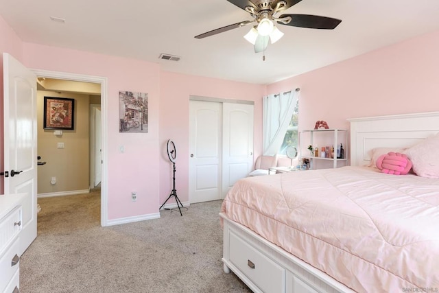 carpeted bedroom with ceiling fan and a closet