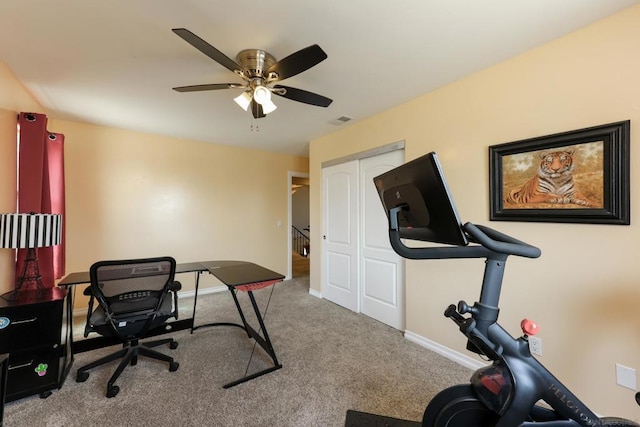 exercise area featuring ceiling fan and light colored carpet